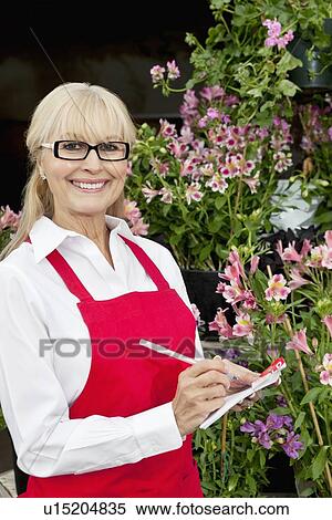 Portrait of a happy senior florist making notes in greenhouse View Large Photo Image Stock Photography - Portrait of a happy senior florist making notes in greenhouse. Fotosearch