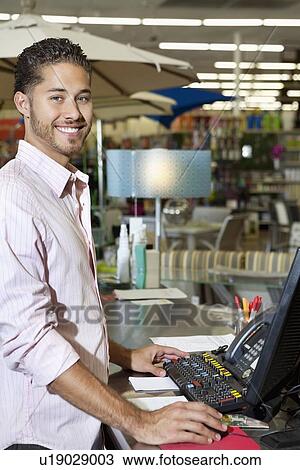 Stock Image - Portrait of a happy store clerk in shop. Fotosearch
