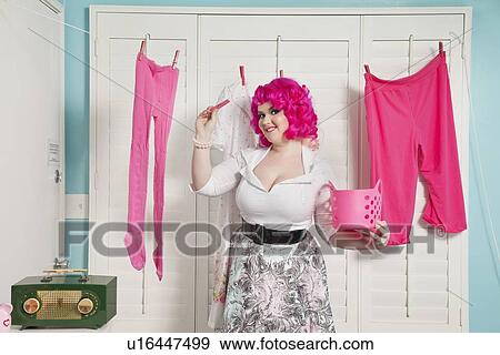 Portrait of a happy woman showing clothespin View Large Photo Image Stock Photo - Portrait of a happy woman showing clothespin. Fotosearch