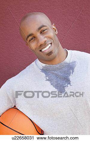 Portrait of a happy young African American man with basketball over colored background View Large Photo Image Stock Image - Portrait of a happy young African American man with basketball over colored background. Fotosearch