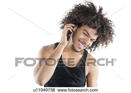 Stock Photo - Portrait of a happy young man listening to mobile phone over white background. Fotosearch