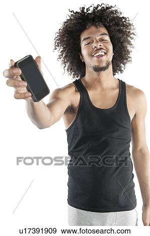 Portrait of a happy young man showing mobile phone over white background View Large Photo Image Stock Photo - Portrait of a happy young man showing mobile phone over white background. Fotosearch