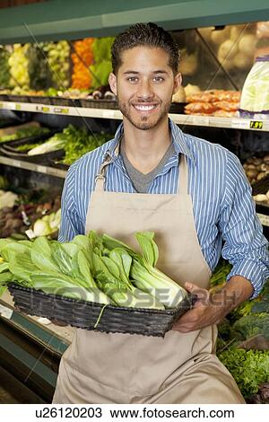 Portrait of a happy young salesperson with bok choy in market View Large Photo Image Stock Image - Portrait of a happy young salesperson with bok choy in market. Fotosearch