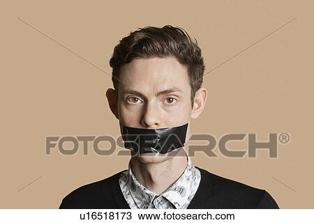 Portrait of a mid adult man with tape on mouth over colored background View Large Photo Image Stock Image - Portrait of a mid adult man with tape on mouth over colored background. Fotosearch