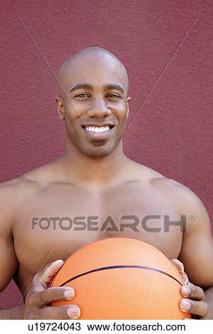 Portrait of a shirtless African American man with basketball over colored background View Large Photo Image Stock Image - Portrait of a shirtless African American man with basketball over colored background. Fotosearch