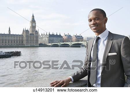 Portrait of a smiling African American businessman with buildings in background View Large Photo Image Stock Image - Portrait of a smiling African American businessman with buildings in background. Fotosearch