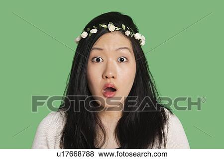 Portrait of a surprised young woman over green background View Large Photo Image Stock Photo - Portrait of a surprised young woman over green background. Fotosearch
