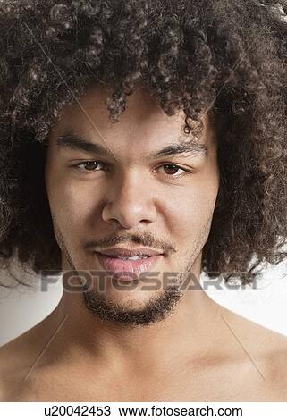 Portrait of a trendy young man with curly hair over white background View Large Photo Image Stock Image - Portrait of a trendy young man with curly hair over white background. Fotosearch