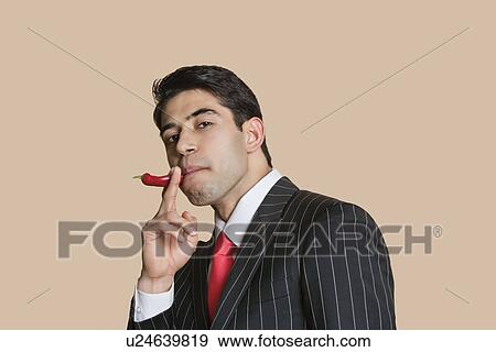 Portrait of a young businessman with red chili pepper imitating as smoking cigarette View Large Photo Image Stock Photo - Portrait of a young businessman with red chili pepper imitating as smoking cigarette. Fotosearch