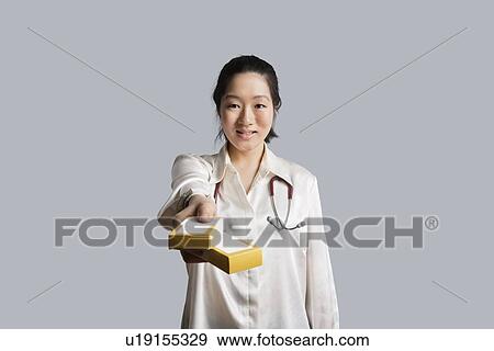 Portrait of a young female doctor giving medicine boxes View Large Photo Image Stock Photo - Portrait of a young female doctor giving medicine boxes. Fotosearch