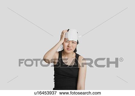 Stock Photo - Portrait of a young female in pain with serious head injury. Fotosearch