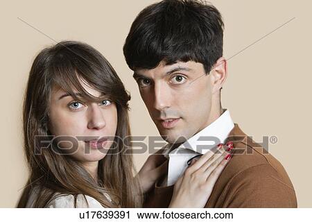 Stock Image - Portrait of a young Hispanic couple over colored background. Fotosearch