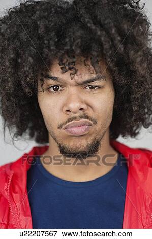 Stock Photo - Portrait of a young man with raised eyebrow. Fotosearch