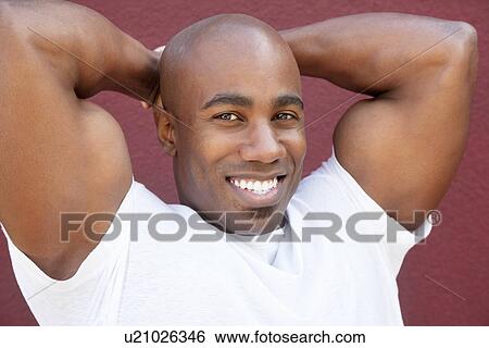 Portrait of a young physically fit African American man with hands behind head View Large Photo Image Stock Photograph - Portrait of a young physically fit African American man with hands behind head. Fotosearch
