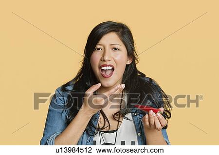 Portrait of a young woman eating red hot chili pepper over colored background View Large Photo Image Stock Image - Portrait of a young woman eating red hot chili pepper over colored background. Fotosearch
