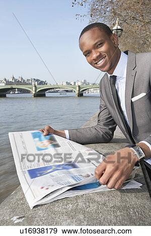 Portrait of African American businessman reading newspaper View Large Photo Image Stock Photo - Portrait of African American businessman reading newspaper. Fotosearch