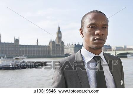Portrait of an African American businessman standing in front of river View Large Photo Image Stock Photograph - Portrait of an African American businessman standing in front of river. Fotosearch