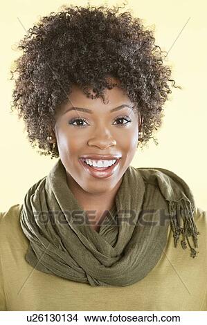 Picture - Portrait of an African American woman with a stole round her neck smiling over colored background. Fotosearch