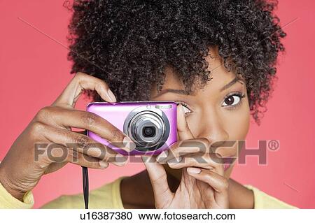 Portrait of an African American woman taking picture from camera over colored background View Large Photo Image Stock Image - Portrait of an African American woman taking picture from camera over colored background. Fotosearch