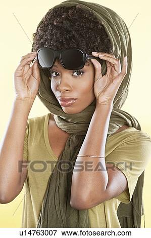 Portrait of an African American woman holding sunglasses with a stole over her head View Large Photo Image Stock Photo - Portrait of an African American woman holding sunglasses with a stole over her head. Fotosearch