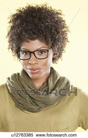 Stock Photography - Portrait of an African American woman wearing glasses over colored background. Fotosearch