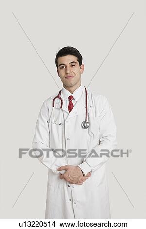 Portrait of an Indian male doctor smiling over gray background View Large Photo Image Picture - Portrait of an Indian male doctor smiling over gray background. Fotosearch