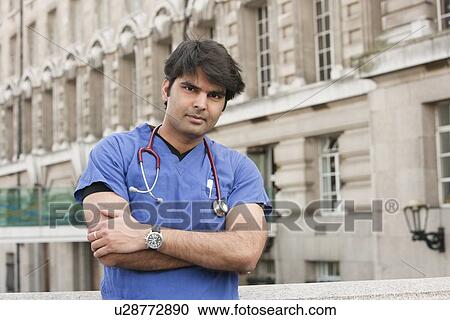 Portrait of an Indian male doctor standing with arms crossed View Large Photo Image Stock Image - Portrait of an Indian male doctor standing with arms crossed. Fotosearch
