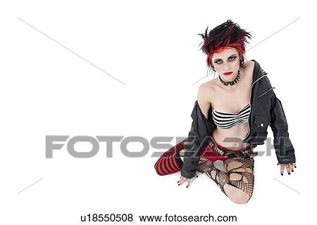 Stock Photo - Portrait of beautiful young punk woman sitting over white background. Fotosearch