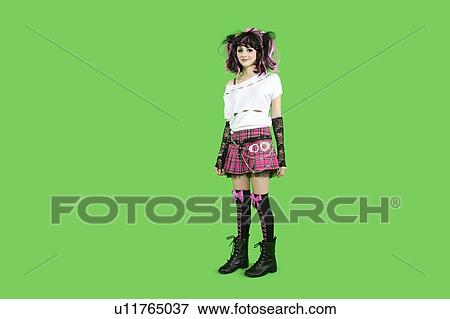 Stock Photo - Portrait of beautiful young woman standing over green background. Fotosearch
