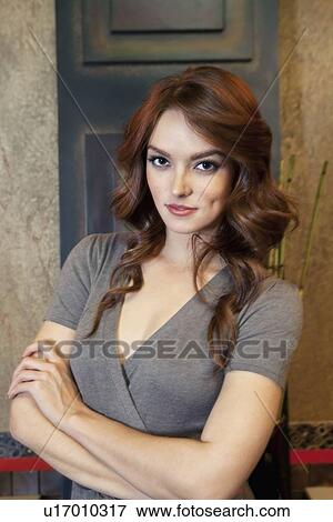 Portrait of beautiful young woman with arms crossed in model home View Large Photo Image Stock Photo - Portrait of beautiful young woman with arms crossed in model home. Fotosearch
