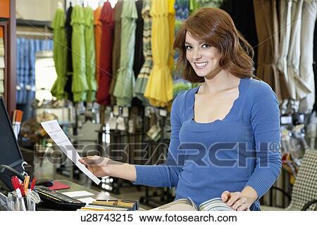 Portrait of beautiful young woman with paper and textile samples standing in store View Large Photo Image Stock Photography - Portrait of beautiful young woman with paper and textile samples standing in store. Fotosearch