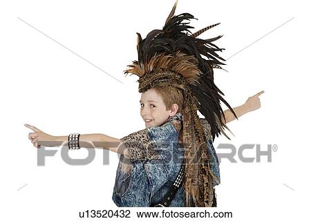 Stock Image - Portrait of boy in costume with headdress looking back over white background. Fotosearch
