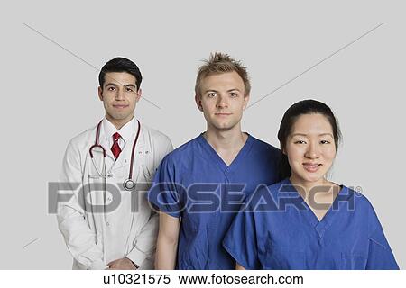 Stock Photography - Portrait of confident multi ethnic medical team standing over gray background. Fotosearch