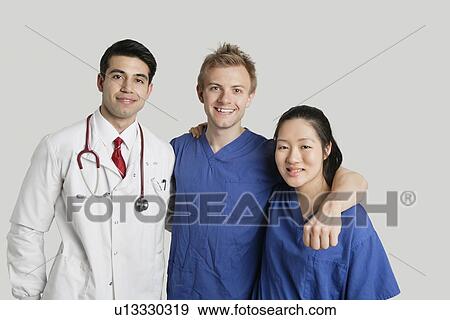 Portrait of friendly medical team standing over gray background View Large Photo Image Stock Photo - Portrait of friendly medical team standing over gray background. Fotosearch