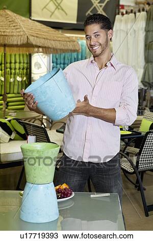 Portrait of handsome man holding a souvenir in store View Large Photo Image Stock Image - Portrait of handsome man holding a souvenir in store. Fotosearch