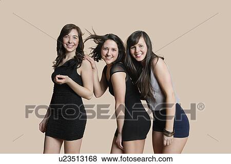 Portrait of happy young friends posing over colored background View Large Photo Image Stock Photo - Portrait of happy young friends posing over colored background. Fotosearch