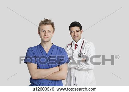 Portrait of male nurse and doctor standing with arms crossed over gray background View Large Photo Image Stock Photograph - Portrait of male nurse and doctor standing with arms crossed over gray background. Fotosearch