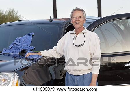 Stock Photo - Portrait of mature man standing next to his car. Fotosearch