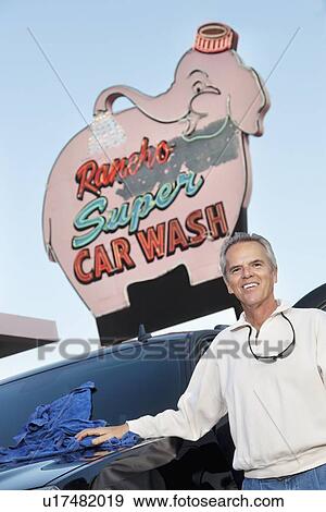 Portrait of mature owner of car wash standing below signboard with vehicle View Large Photo Image Stock Photo - Portrait of mature owner of car wash standing below signboard with vehicle. Fotosearch