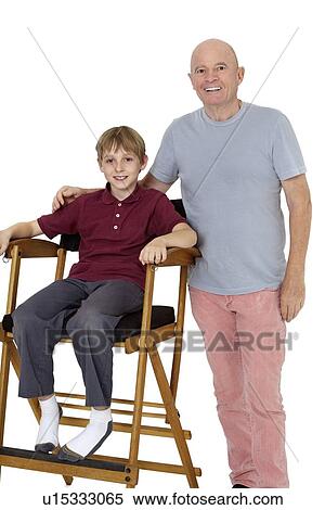 Portrait of senior man with pre-teen boy sitting on director's chair over white background View Large Photo Image Stock Photography - Portrait of senior man with pre-teen boy sitting on director's chair over white background. Fotosearch