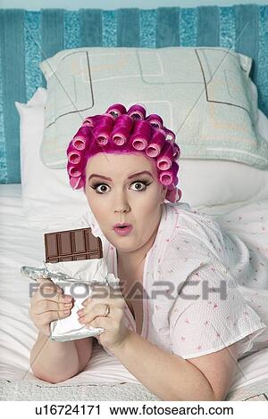 Portrait of shocked woman lying on bed with chocolate bar View Large Photo Image Stock Image - Portrait of shocked woman lying on bed with chocolate bar. Fotosearch