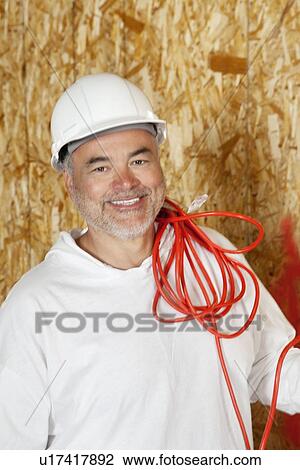 Portrait of smiling male construction worker with a red electrical wire View Large Photo Image Stock Image - Portrait of smiling male construction worker with a red electrical wire. Fotosearch