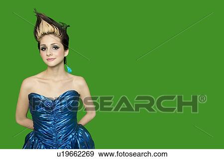 Portrait of spiked hair young woman with hands behind back over green background View Large Photo Image Stock Photo - Portrait of spiked hair young woman with hands behind back over green background. Fotosearch
