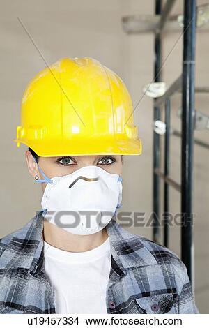 Portrait of woman worker wearing dust mask at construction site View Large Photo Image Picture - Portrait of woman worker wearing dust mask at construction site. Fotosearch