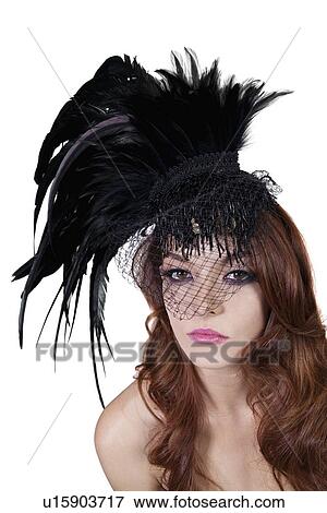 Stock Photo - Portrait of young brunette wearing feathered veil over white background. Fotosearch