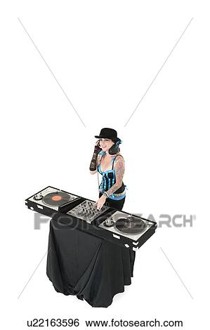 Stock Photograph - Portrait of young DJ with sound mixing equipment wearing hat over white background. Fotosearch
