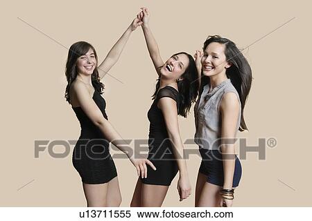 Portrait of young female friends dancing over colored background View Large Photo Image Stock Photography - Portrait of young female friends dancing over colored background. Fotosearch