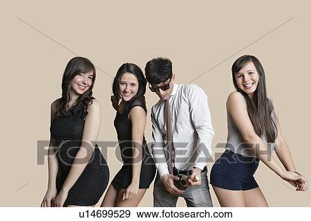 Portrait of young friends posing with champagne over colored background View Large Photo Image Stock Photo - Portrait of young friends posing with champagne over colored background. Fotosearch
