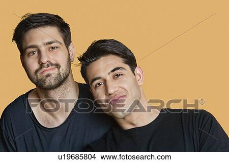 Picture - Portrait of young male friends over colored background. Fotosearch