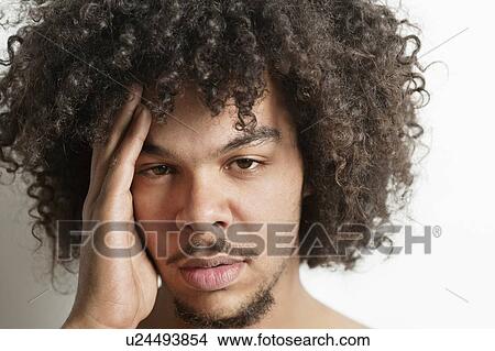 Portrait of young man having headache over white background View Large Photo Image Picture - Portrait of young man having headache over white background. Fotosearch